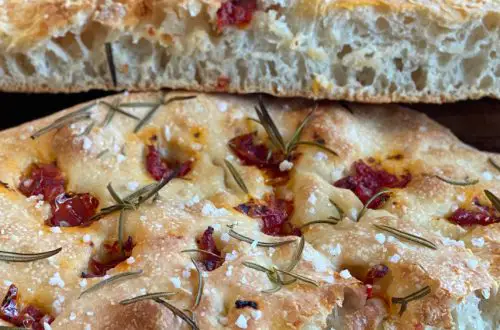 Focaccia Aufgeschnitten, fluffig Teig, große Porung, belegt mit Rosmarin und getrockneten Tomaten