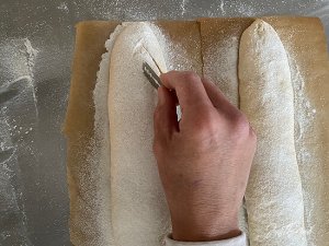 Teiglinge der Brotstangen werden vor der Stückgare eingeschnitten