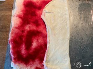 Teig mit Farbpulver laminieren: Teig dünn ausdehnen, Puder verteilen und zum Päckchen zusammenfalten