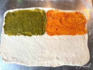 Knusperstangen: Fertig ausgrollten Teig (ca. 45 x 30 cm) mit einem Pesto / Aufstrich deiner Wahl auf einer Hälfte bestreichen.