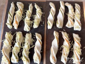 Knusperstangen: Die gedrehten Stangen können noch mit geriebenem Köäse bestreut werden.