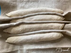 Teig teilen und ausrollen. Teig portionieren und zu Pizza-Stangen ausrollen: So wird der Teig perfekt vorbereitet für den Belag.