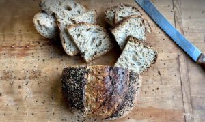Saftiges Sauerteigbrot mit Saaten – gebacken mit 2-stufig geführtem Roggensauerteig für intensives Aroma und lange Frischhaltung. Knusprige Kruste, lockere Krume mit Sonnenblumenkernen, Sesam und Leinsamen. Perfekt als Pausenbrot, Sandwich oder Beilagenbrot. Ideal für eine ausgewogene Ernährung mit Vollkorn und gesunden Saaten.