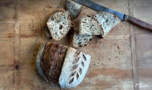 Saftiges Sauerteigbrot mit Saaten – gebacken mit 2-stufig geführtem Roggensauerteig für intensives Aroma und lange Frischhaltung. Knusprige Kruste, lockere Krume mit Sonnenblumenkernen, Sesam und Leinsamen. Perfekt als Pausenbrot, Sandwich oder Beilagenbrot. Ideal für eine ausgewogene Ernährung mit Vollkorn und gesunden Saaten.