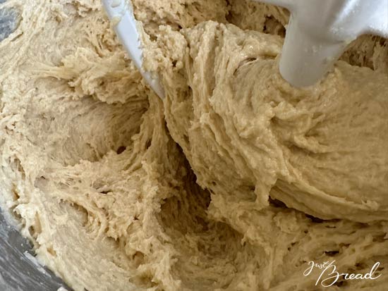Zutaten für Flammkuchenteig mit Weizen-Anstellgut in Schüsseln, Teig wird per Hand oder mit einem Teigkneter geknetet.