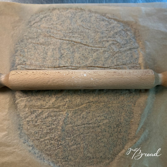 Teig für die Sauerteig-Cracker mit einem Nudelholz dünn ausrollen