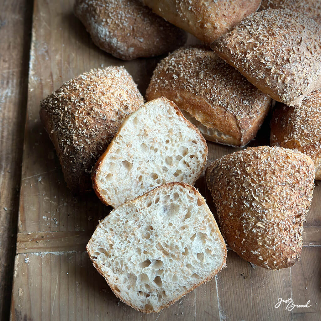 Frisch gebackene Weizenschrotbrötchen mit knuspriger, rustikaler Kruste.