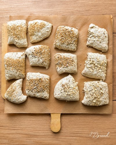 Zucchini Brötchen vor dem Backen: Brötchen mit Saaten bestreuen