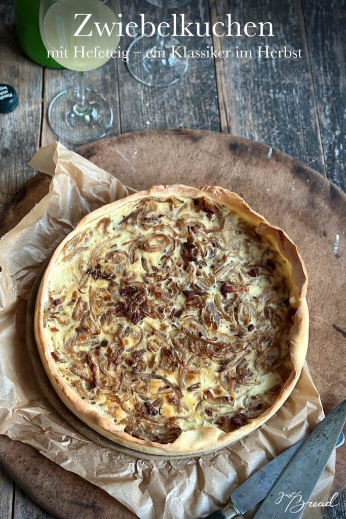 Zwiebelkuchen mit Hefeteig, frisch gebacken in der Springform auf einem Holzbrett