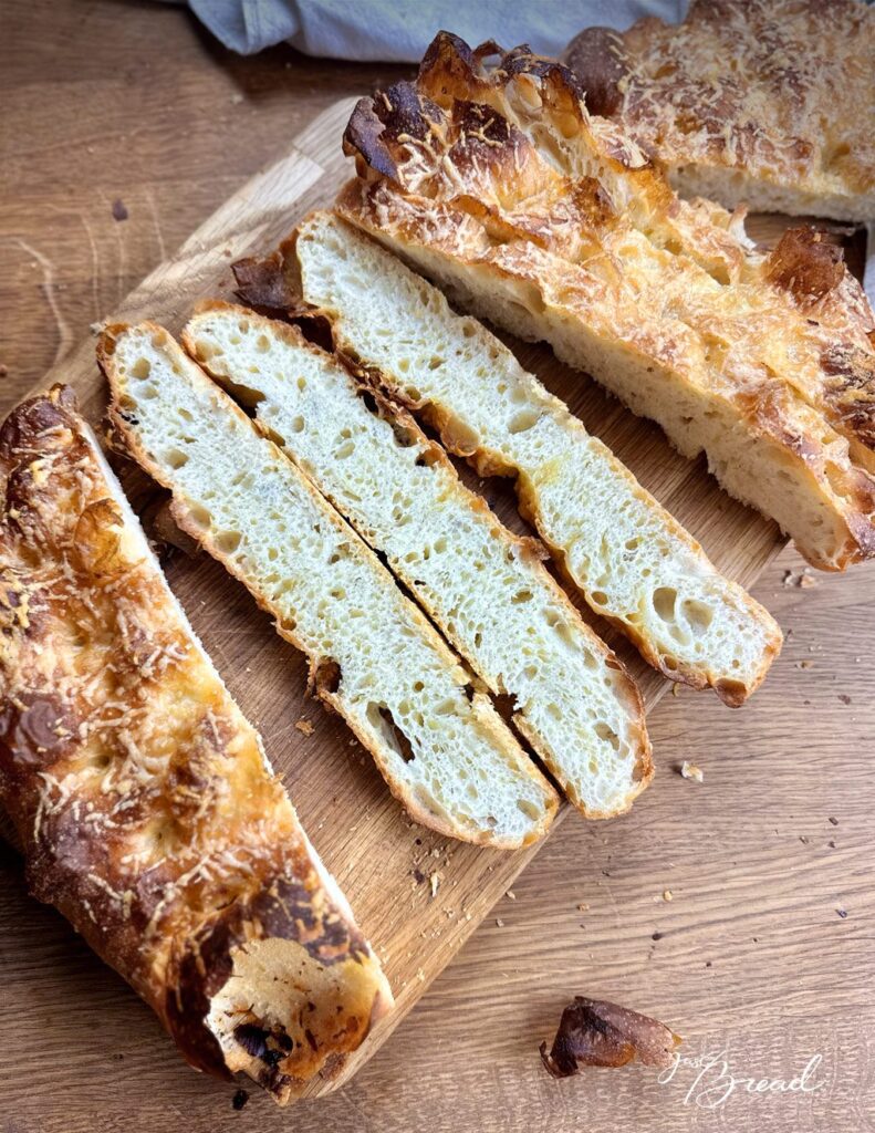 Aufgeschnittene Kartoffel-Käse-Focaccia mit heller, saftiger Krume und knuspriger Käsekruste