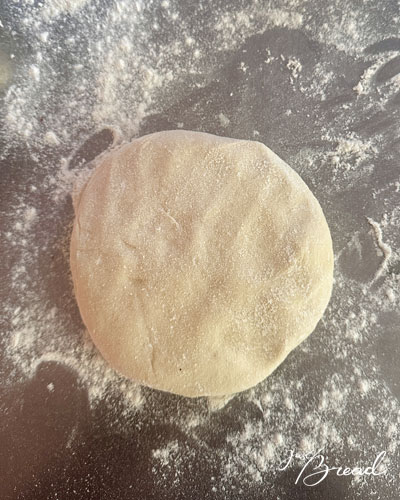 Hefeteig für Zwiebelkuchen nach der Gehzeit auf bemehlter Arbeitsfläche
